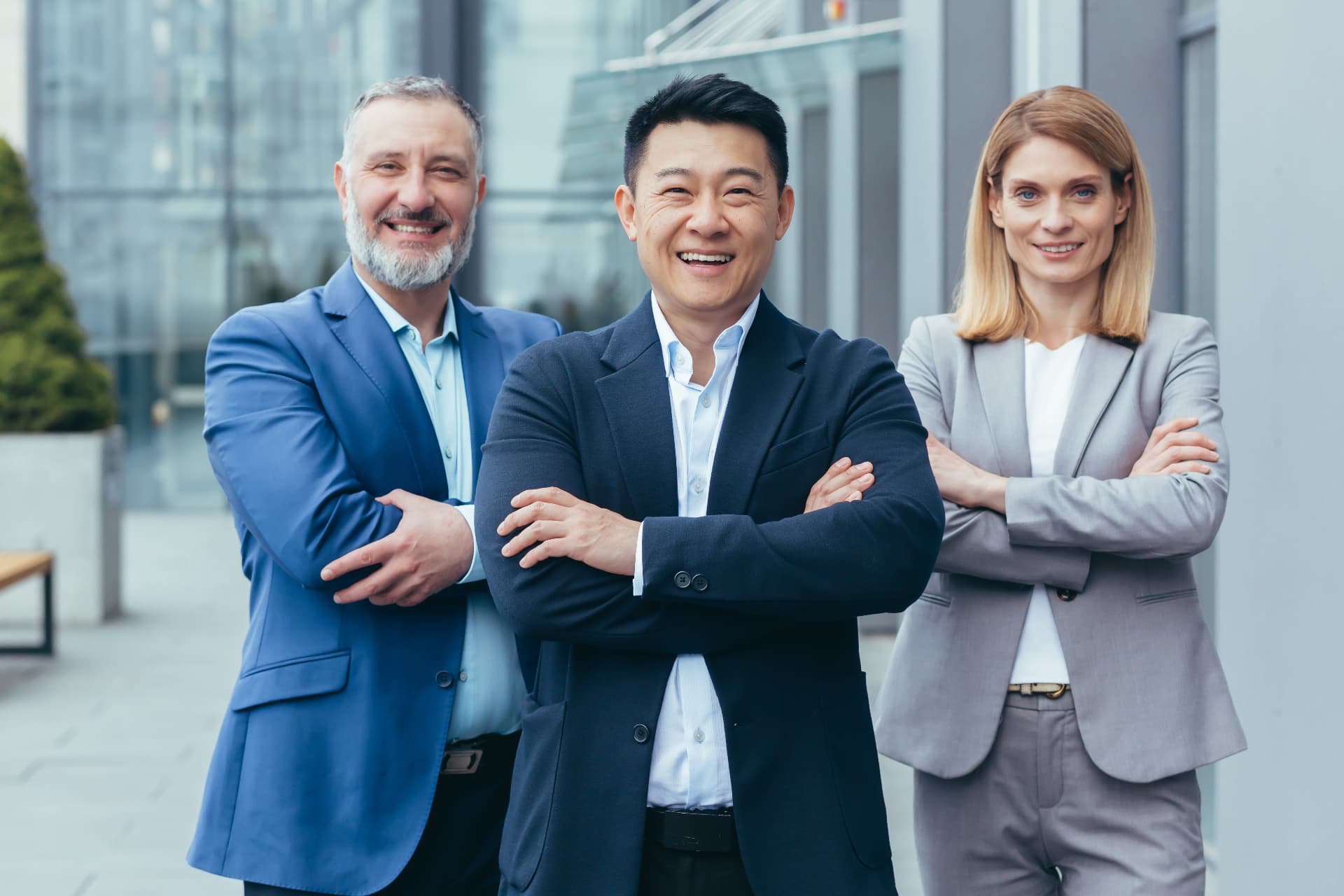Three business professionals standing outside a modern office